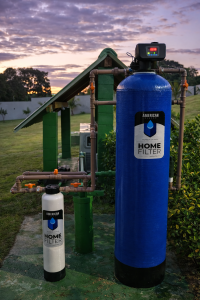 Sistema American Home Filter instalado em área externa com filtro principal e pré-filtro